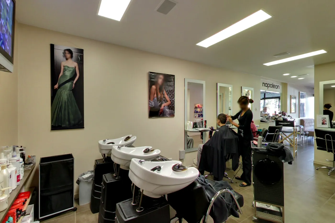 Christina's hair salon with basins, styling stations and a stylist at work