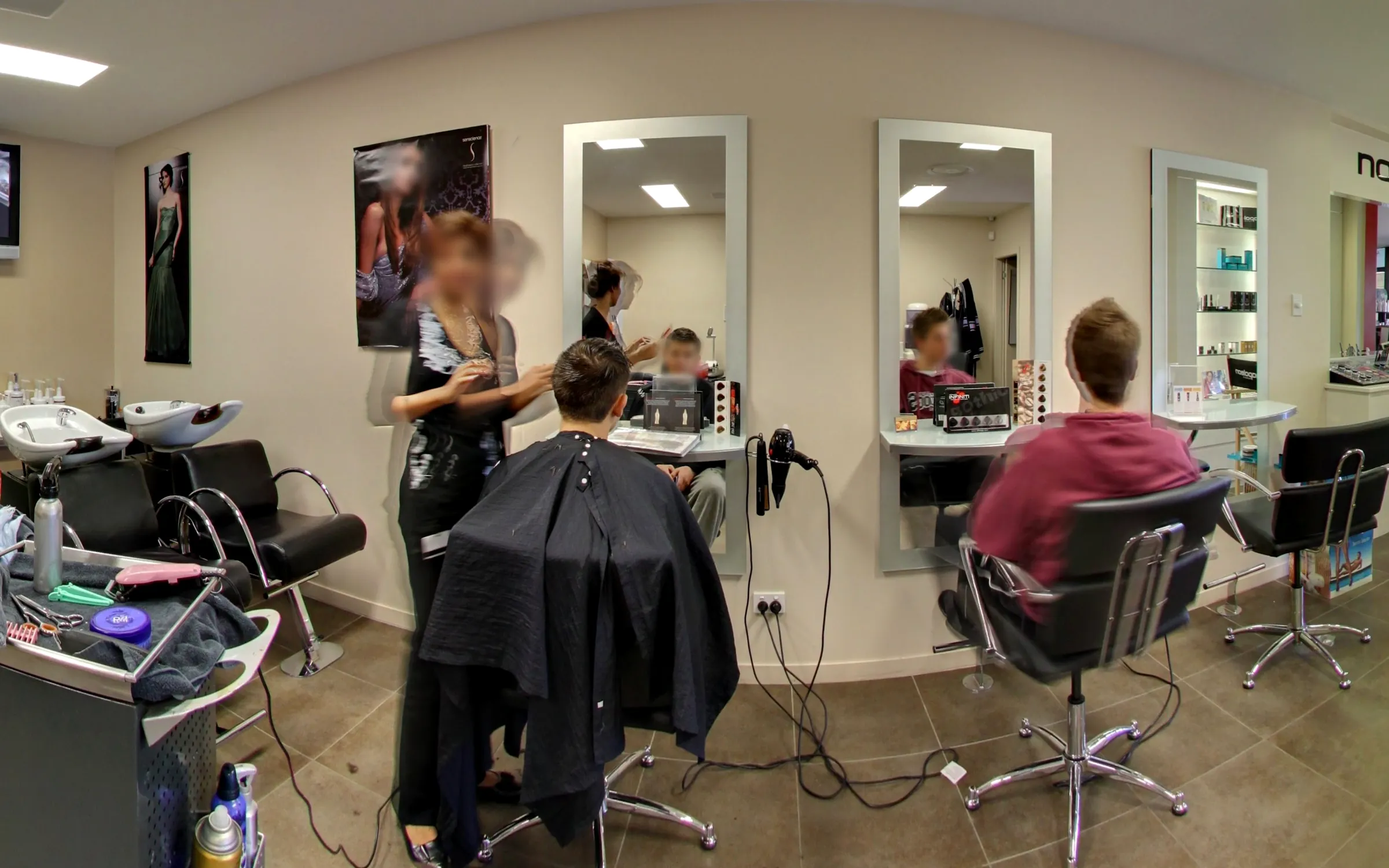 The hair salon floor with basins, mirrors and stylists at work
