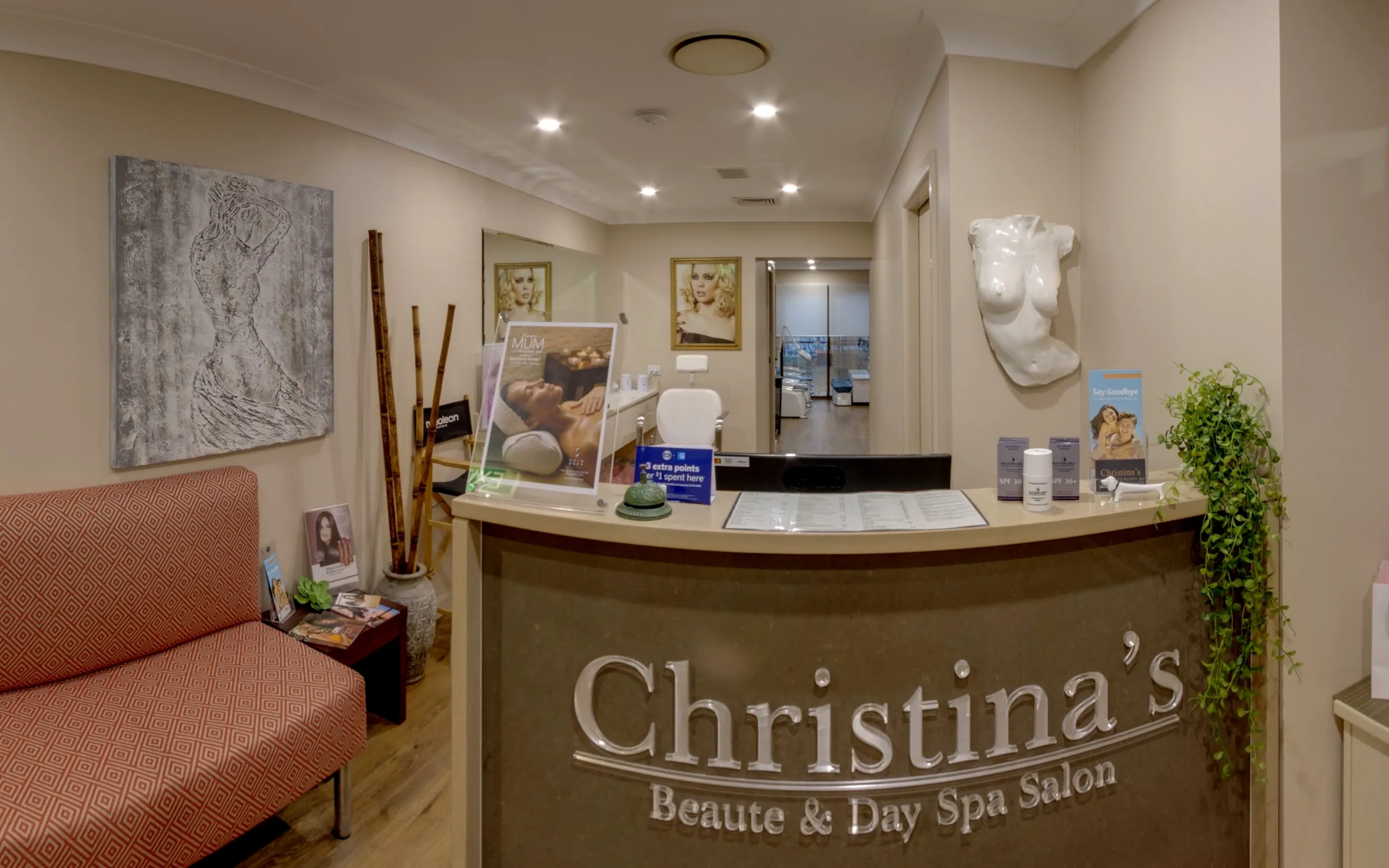 Christina's reception desk with the Christina's sign, a blush lounge and bamboo stems