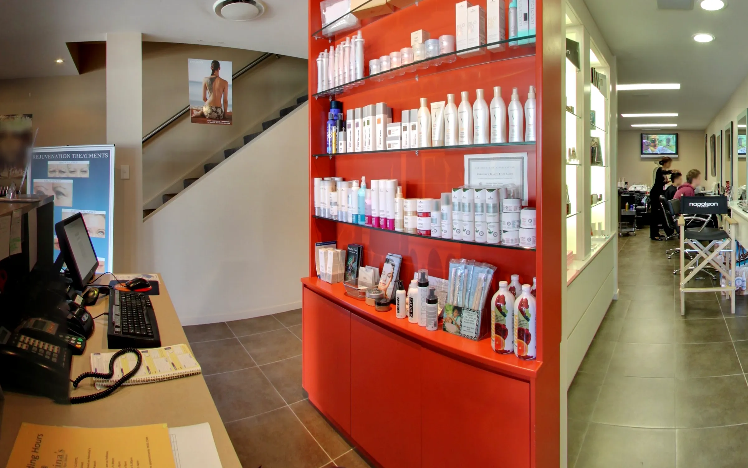 The signature red skincare wall beside the stairs, with the Napoleon make-up counter beyond