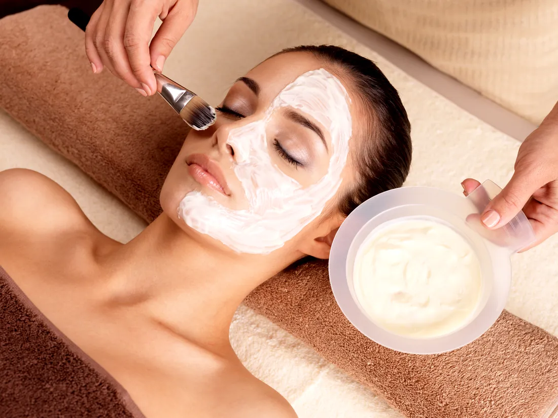 Therapist applying a cream facial mask